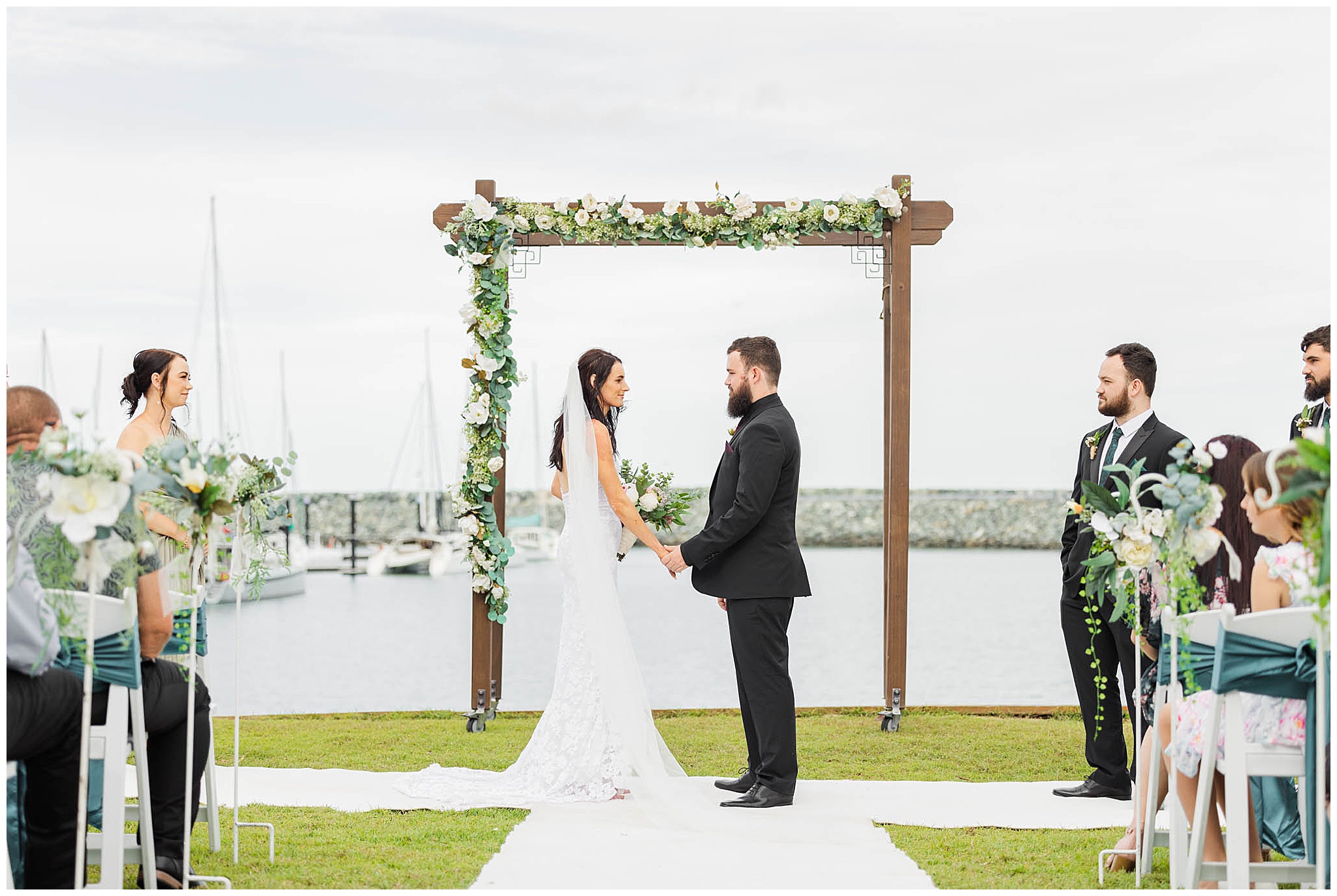 A couple getting married in front of the Mackay Harbour by photographer Alyce Holzy.