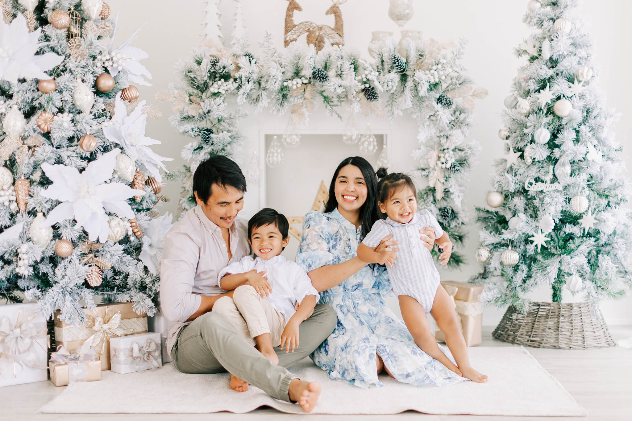 Family sitting in a christmas studio for photos with Alyce Holzy Photography.