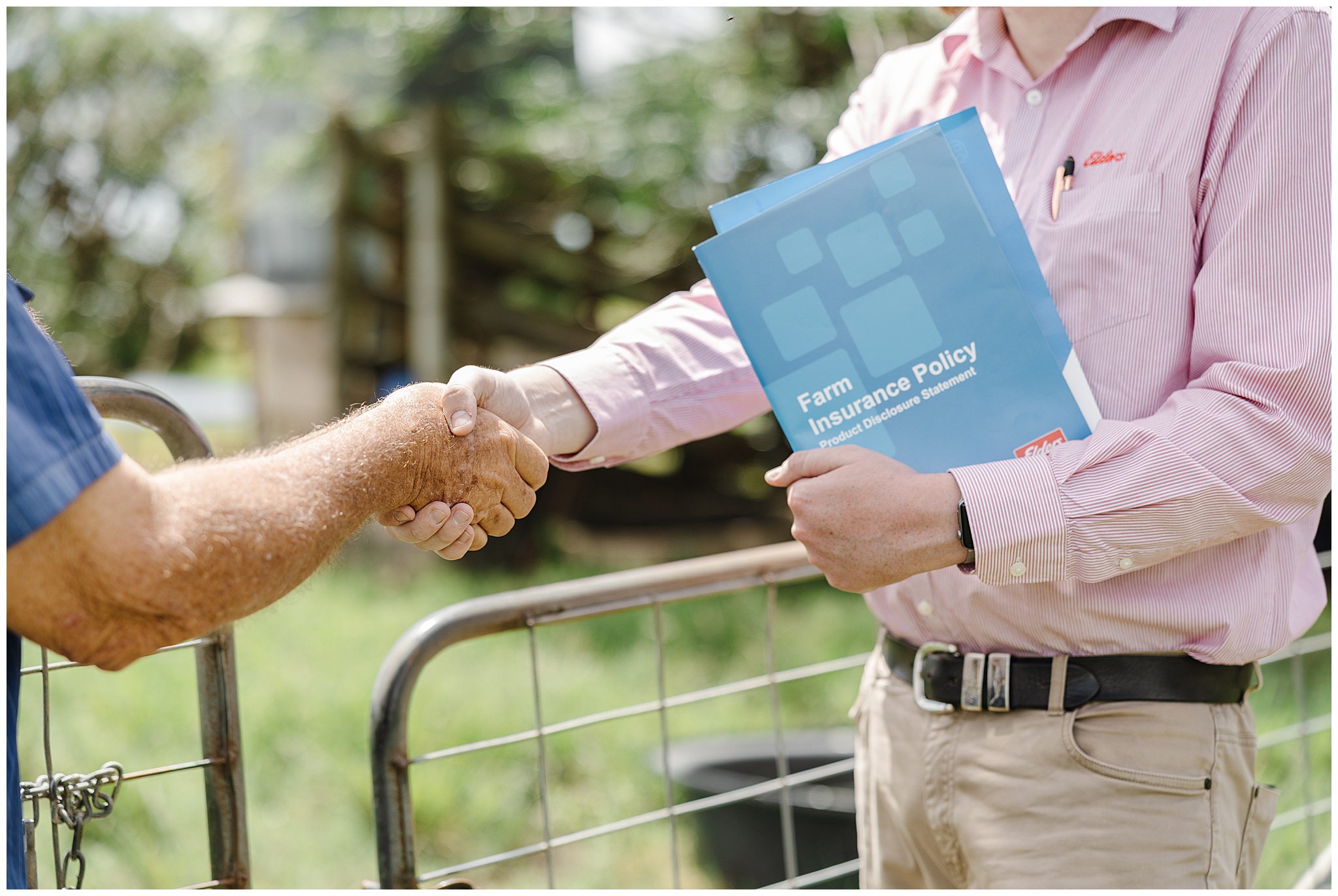 Photo of insurance agent shaking hands with a farmer.